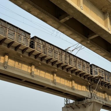 A close-up of an elevated train track structure with clear sky.