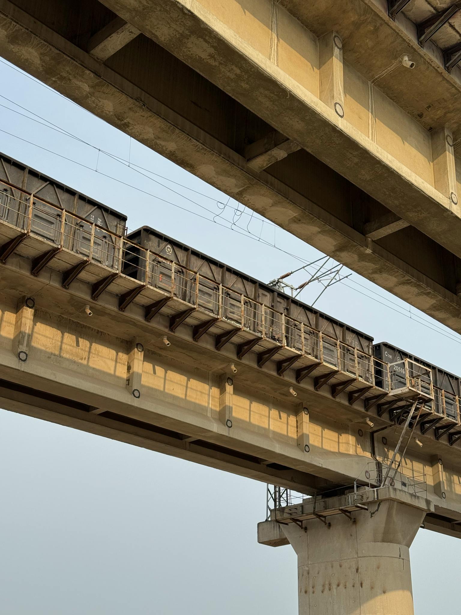 A close-up of an elevated train track structure with clear sky.